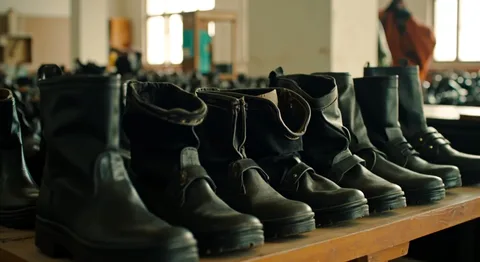 Steel-toe safety boots, school shoes and formal service shoes laid out in rows for a bulk order